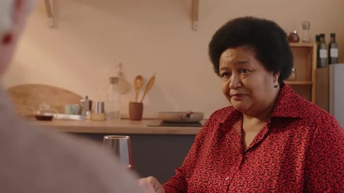 Senior Adults Chat at Table Indoors