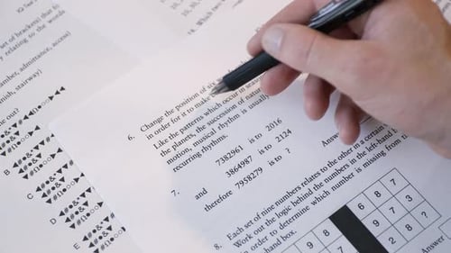 Student Hand Filling Out Multiple Choice Test Sheet, School Exam or Assessment Close-Up. IQ test