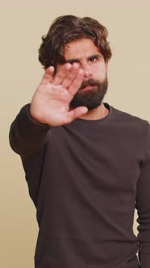 Hindu Man Says No Hold Palm in Stop Gesture Warning of Finish Prohibited Access on Beige Background