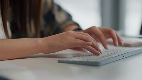 Woman's Hands Typing on Keyboard in Office