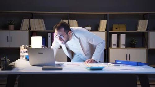 L'homme d'affaires qui travaille la nuit est joyeux et heureux.