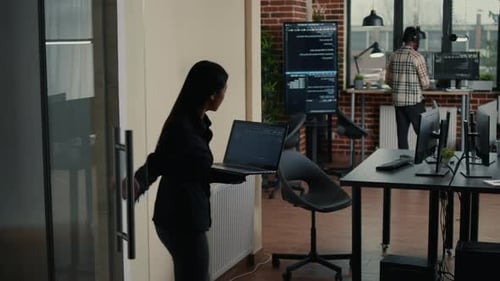 Softwareentwickler nähert sich dem Schreibtisch mit einer Laptop-Programmierschnittstelle