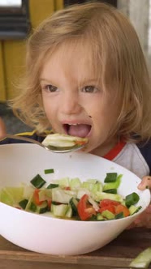 Child Enjoys Fresh Salad for Lunch
