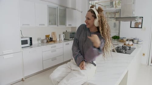 Woman Dancing to Music in Modern Kitchen