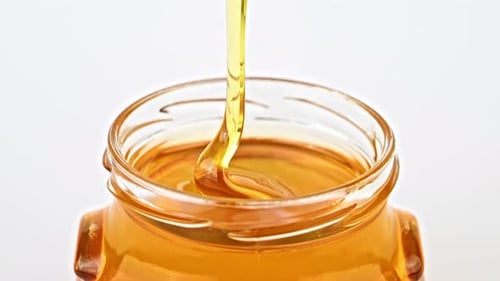 Dripping honey from spoon close up