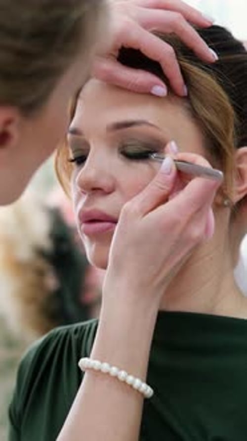 Maquillaje de ojos de cerca, la esteticista aplica sombras de ojos en Bright Professional