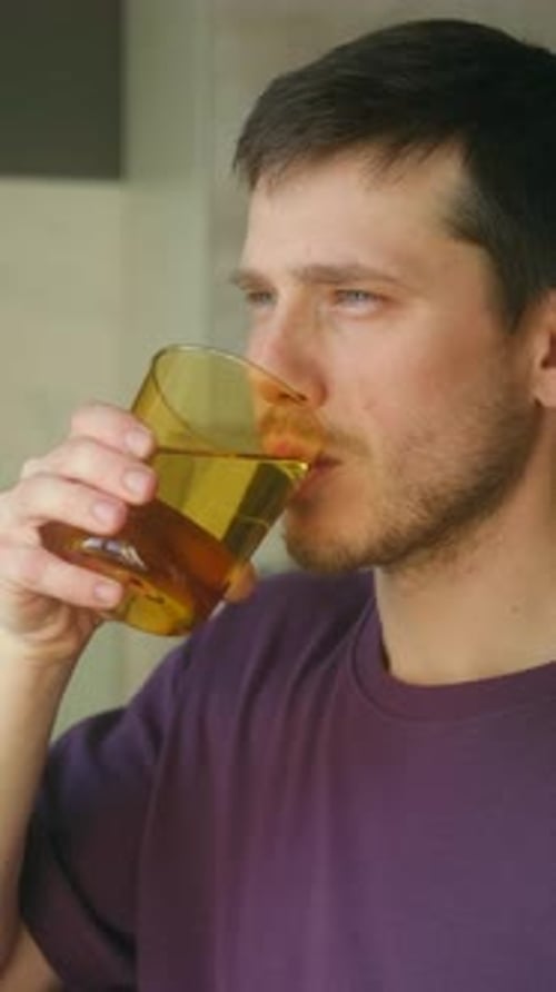 Individual Relaxing During Creative Break While Sipping Drink in Serene Kitchen Setting