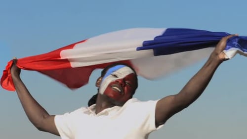 Man with Face Paint Holding Flag in Celebration