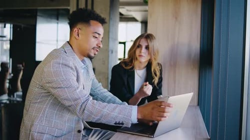 Team Collaborating on Laptop in Modern Office