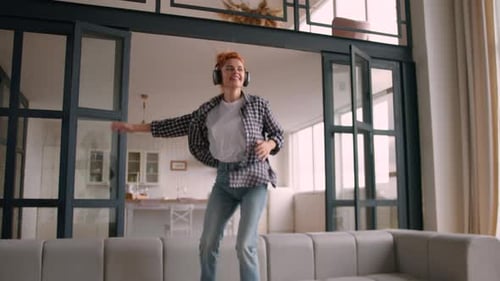 Energetic Woman Dancing and Listening to Music at Home