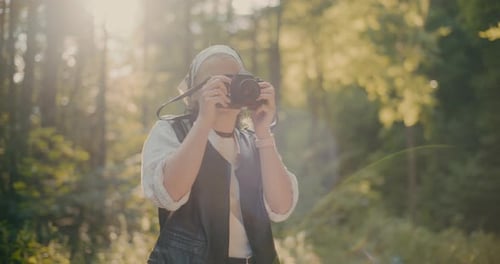 Smiling Tourist Photographing Through Camera In Forest