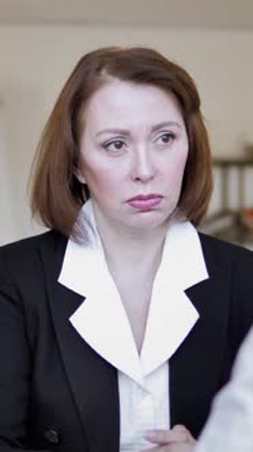 Businesswoman in Black Suit Talks in Office Setting