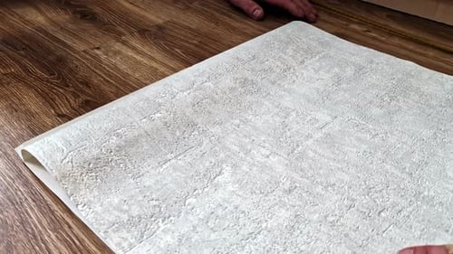 Wallpaper sheet preparation on wooden floor before wall application