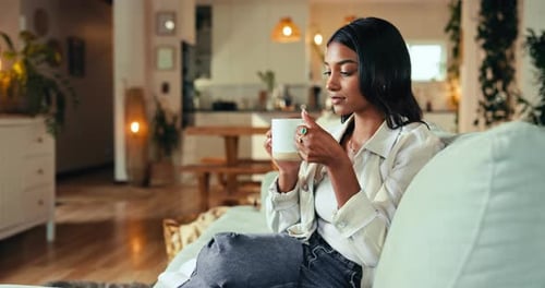 Woman relaxing with a mug on sofa at home