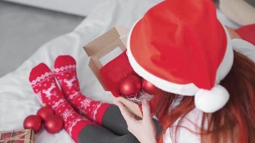 Woman Opens Christmas Baubles at Home