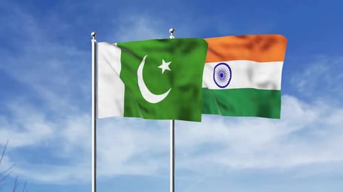 Waving Pakistan and India Flags Against Blue Sky