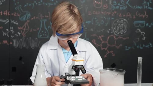 Child Uses Microscope in Science Class with Labware