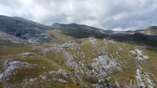 fantastic drone flight to sinjal peak in croatia's dinara mountains, threatening dark clouds on the