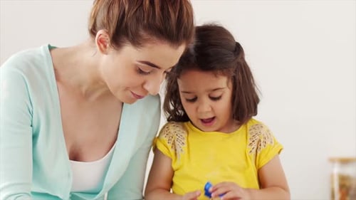 Woman and Girl Bake Together in Kitchen
