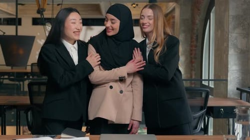 Smiling Women Embrace in Modern Workplace