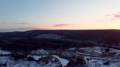 Aerial sunset on winter river valley