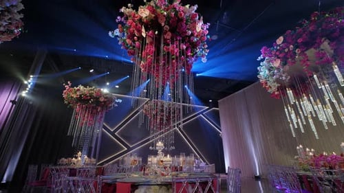 Ornate Wedding Hall with Flower Arrangements and Blue Lights