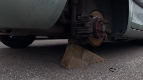 Car with Flat Tire and Dented Bumper Parked Roadside Following Accident