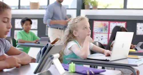 Caucasian girl in a school classroom with a laptop