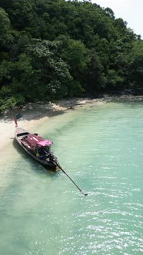 Vertical Video Drone Shot of a Motorboat Speeding in Tropical Waters Near a Thai Island