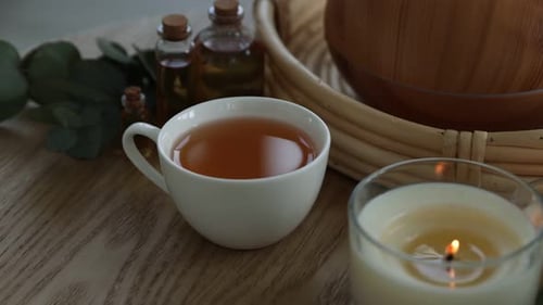 Composição de spa com difusor de óleo aromático e velas acesas na mesa de madeira, closeup. Câmera em movimento
