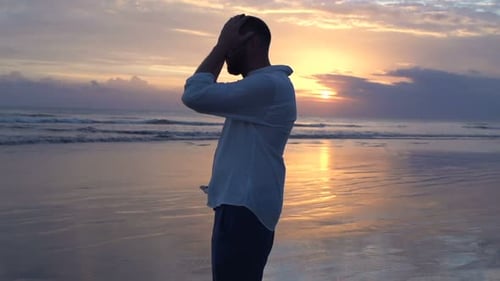 Silhouette Of Sad, Depressed Man On Beach During Sunset
