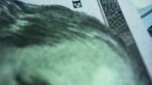 Macro shot pile of one hundred United States dollar bills featuring benjamin franklin