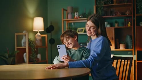 Cheerful Mother and Son Using Mobile Phone at Home