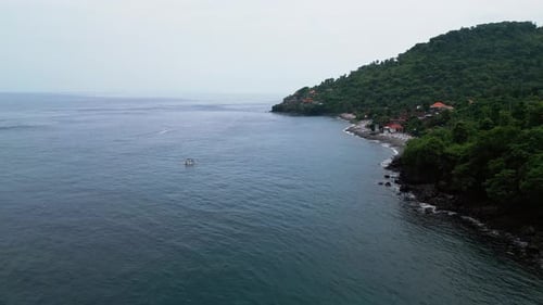 Aerial Footage of Coastal Fishing Village in Indonesia and Anchored Boat in Calm Tropical Bay