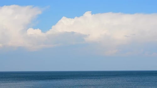 Movement Large White Cumulus Rain Clouds in Blue Sky Over Blue Sea on Sunny Day