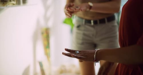 Female friends trying on jewelry and rings in boutique clothing store