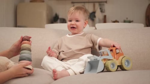 Cute Child Playing with Toys on Sofa