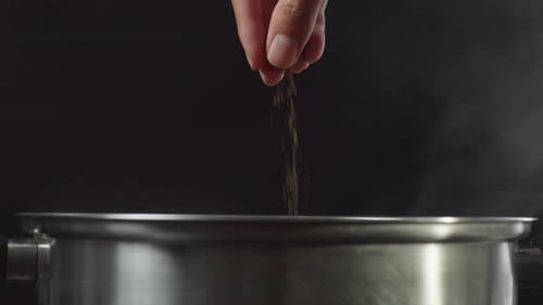 Close Up Of Chef's Hand Adds Pepper In The Soup Pot. Sukiyaki Or Shabu In A Pot