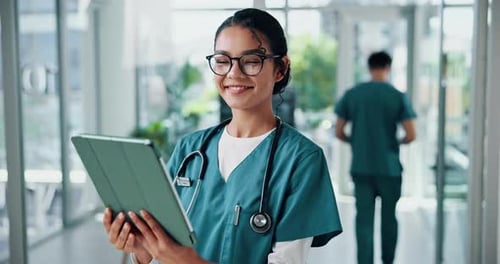 Smiling Medical Professional in Hospital with Tablet