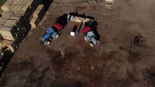 Aerial view of the farm with tractors in Spain. Farmyard at sunset