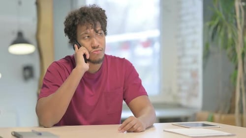 African Man Talking on Phone in Office