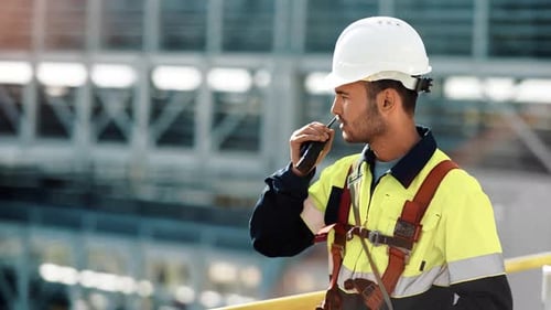 Männlicher Industrieingenieur, Helm, Uniform, Walkie-Talkie in der Manufaktur, im Raffineriebau