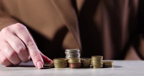 Coins stacked and sorted by hand on table