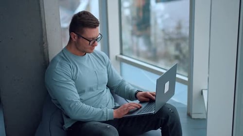 Man Working on Laptop in Modern Workspace