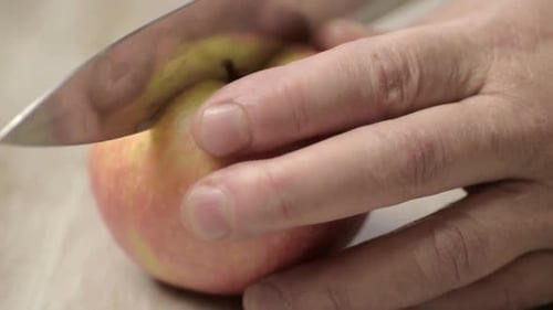 Einen saftigen roten und gelben Apfel mit einem scharfen Messer halbieren