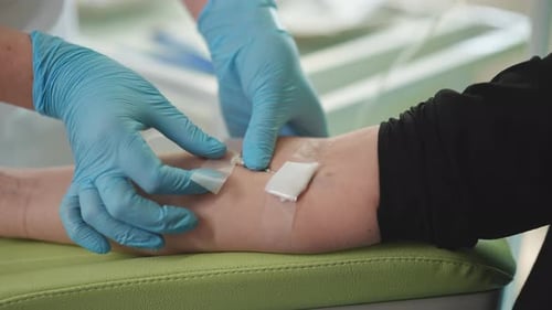 Closeup Hands of Unrecognizable Female Patient with IV Catheter in Vein Receiving Vitamin Treatment