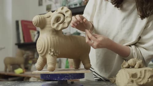 The Ceramicist Girl Adds Small Details to the Base of the Sculpture
