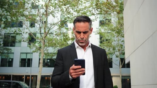 Man in Suit Using Phone in City Street