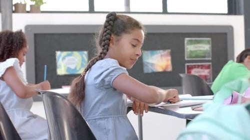 Biracial girl smiles in a classroom setting at school