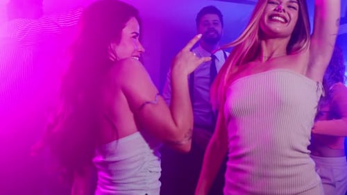 Friends Dancing at Nightclub with Pink and Blue Lights